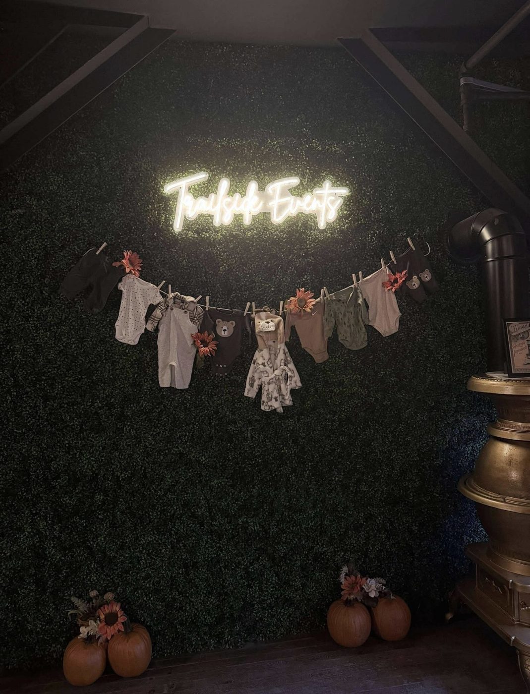 The TrailSide Events neon on the green wall, with a clothesline of baby clothes, pumpkins, and the Lehigh stove.
